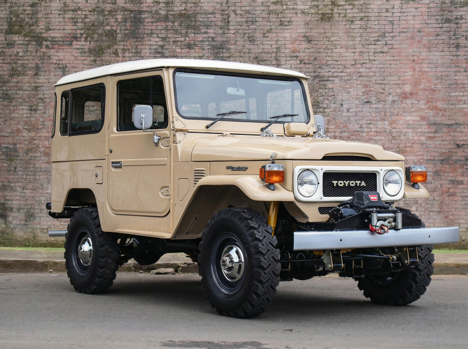 Beige FJ40 Land Cruiser with original wheels and warn winch
