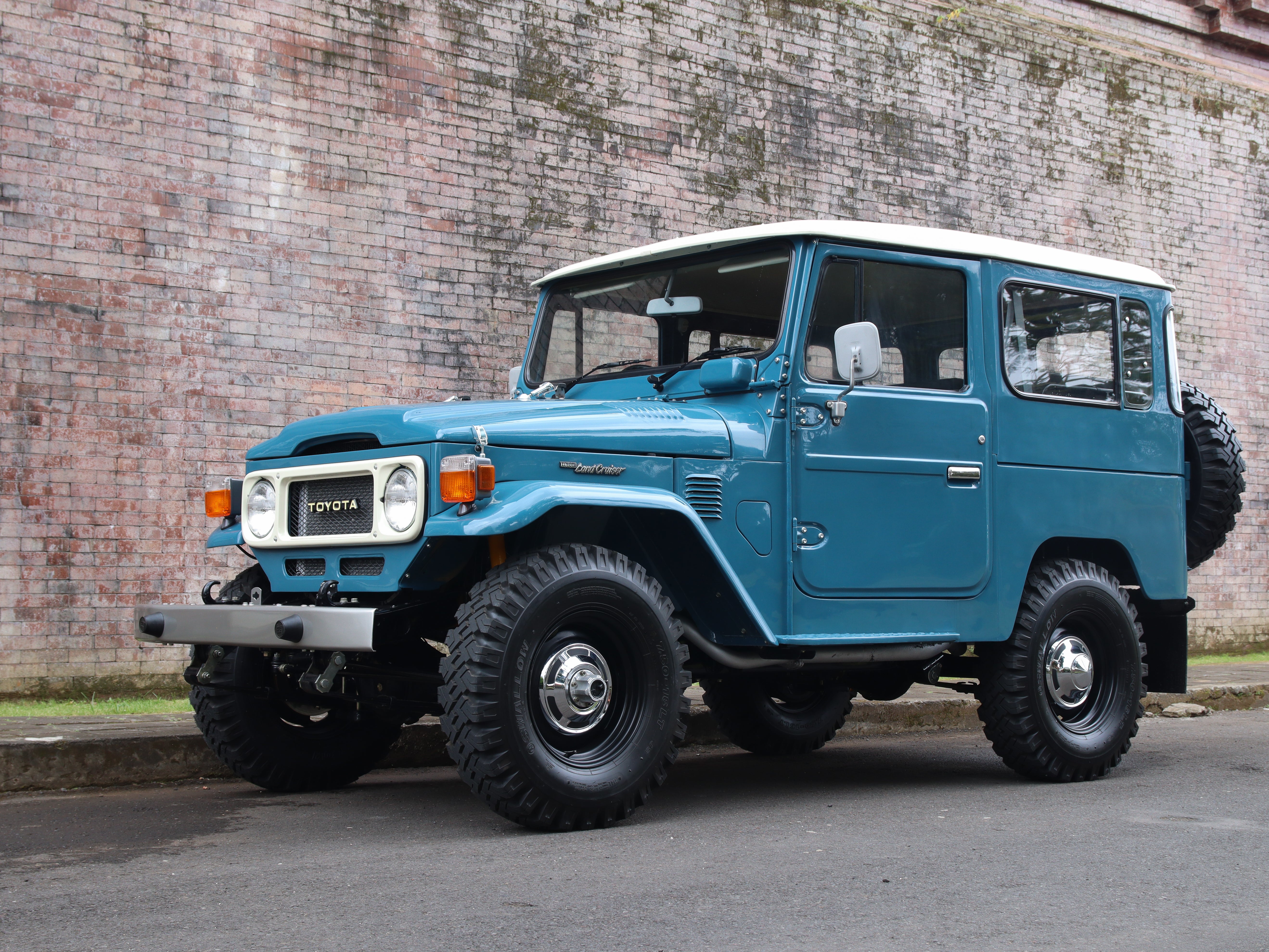 Vintage Toyota Land Cruiser FJ40 parked outdoors, fully restored